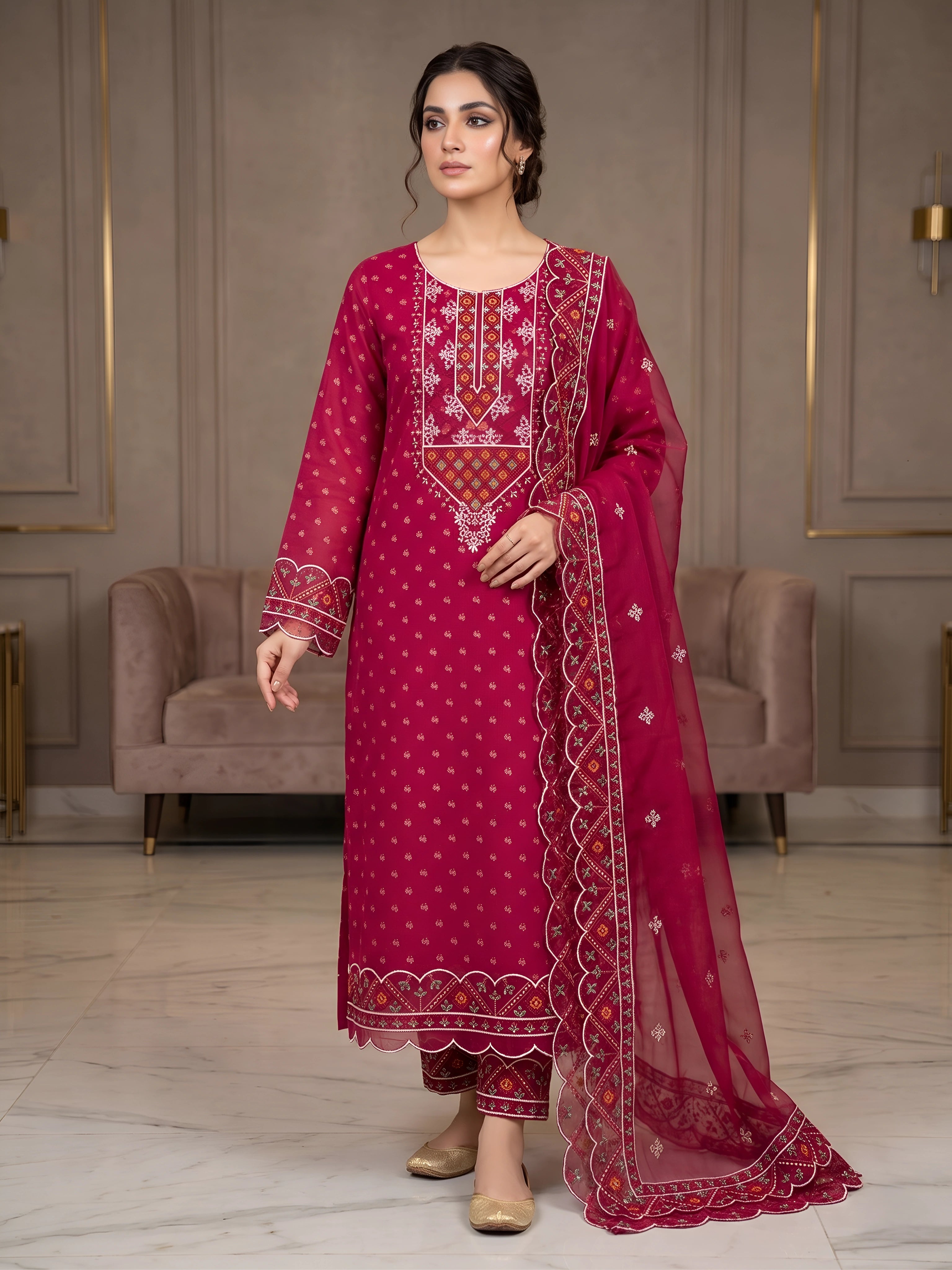 Woman wearing a red embroidered traditional outfit in an elegant room.